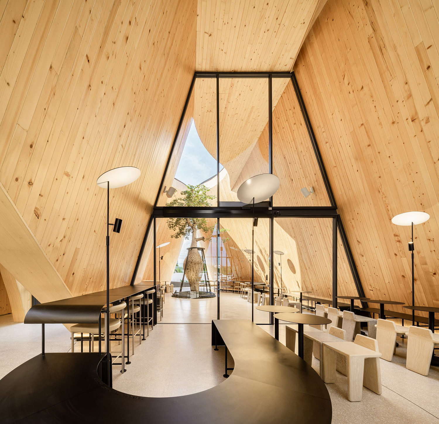 Дерево баобаб растёт в изогнутом кафе в Таиланде от IDIN Architects